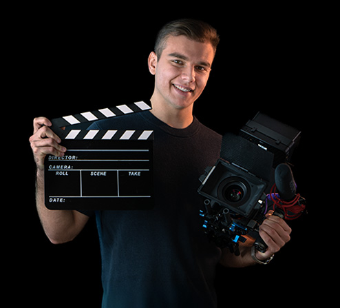 Erick Bensel mit Filmklappe und Kamera