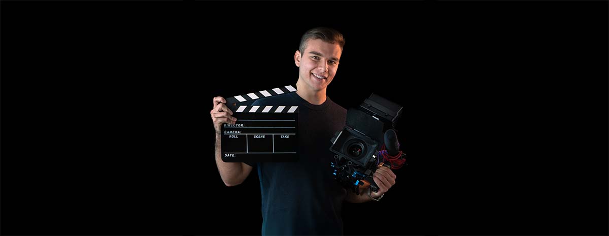 Erick Bensel mit Filmklappe und Kamera